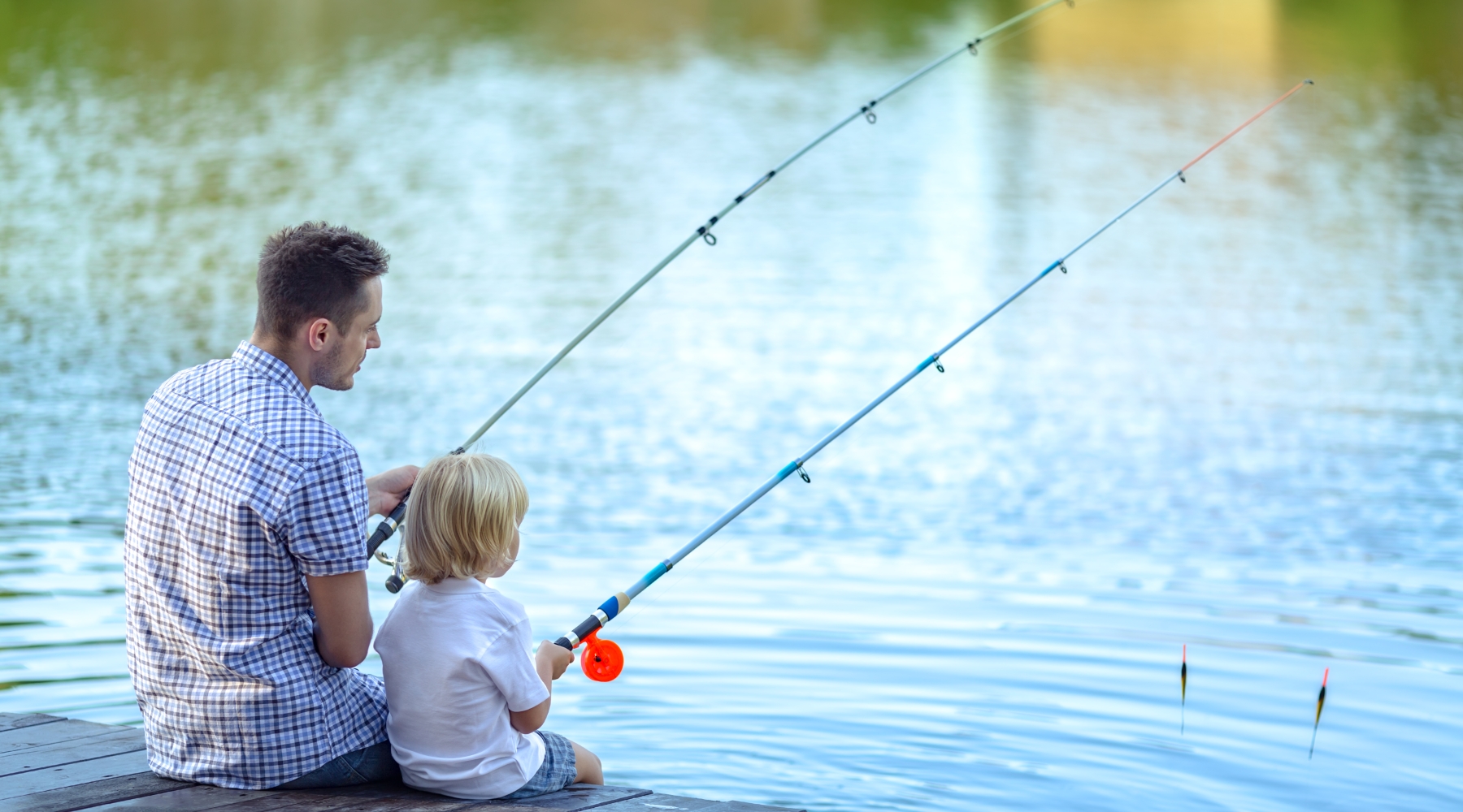 Man fishing with son off a dock