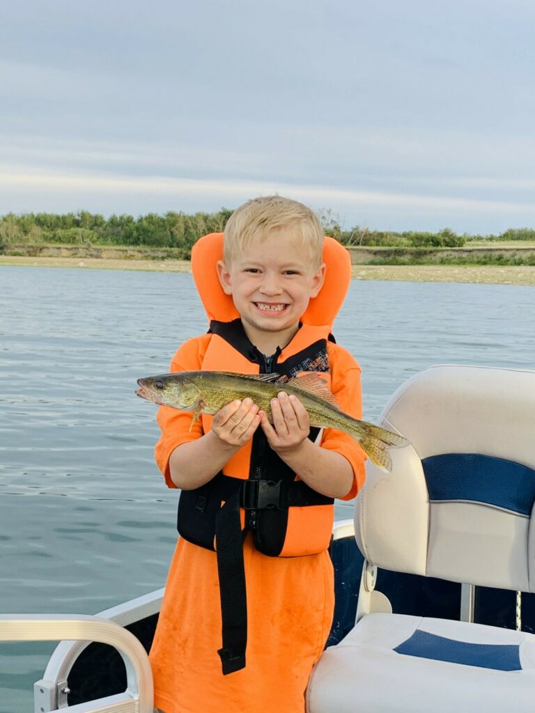 Boy holding a fish he caught on Lake Diefenbaker