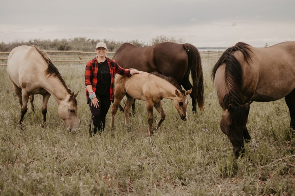 Equine Experiences at Sunset Beach 3 a woman stands amongst 4 horses